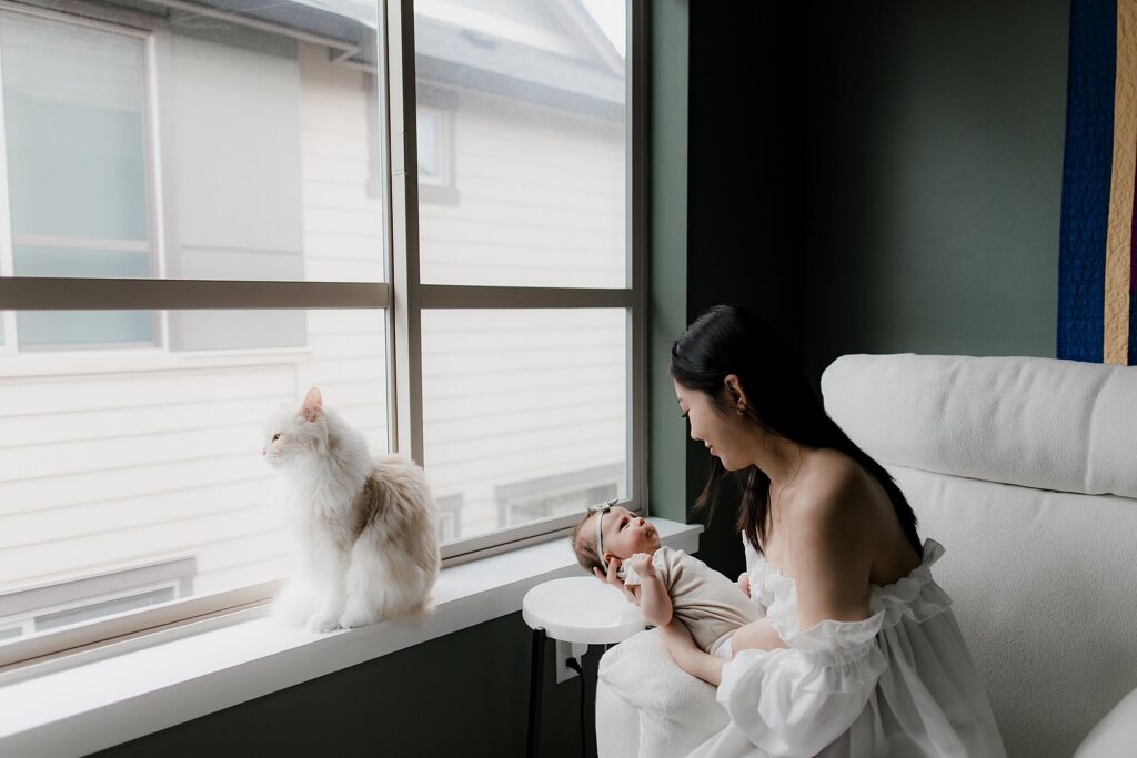 mom holding newborn in home nursery seattle photo session