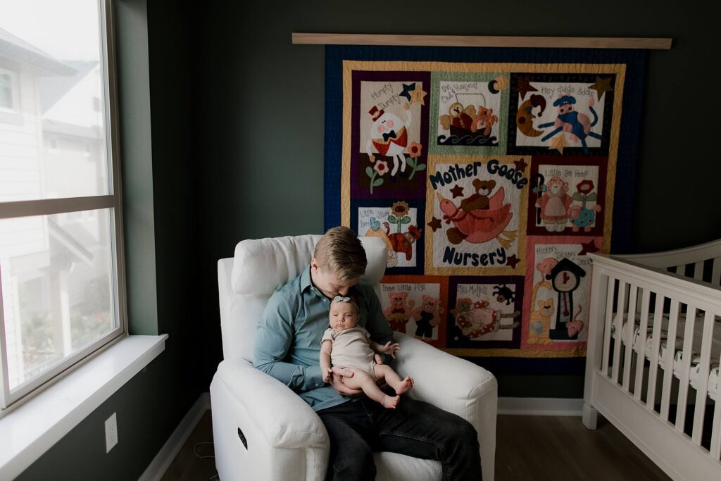 dad holding baby girl in nursery at seattle newborn session
