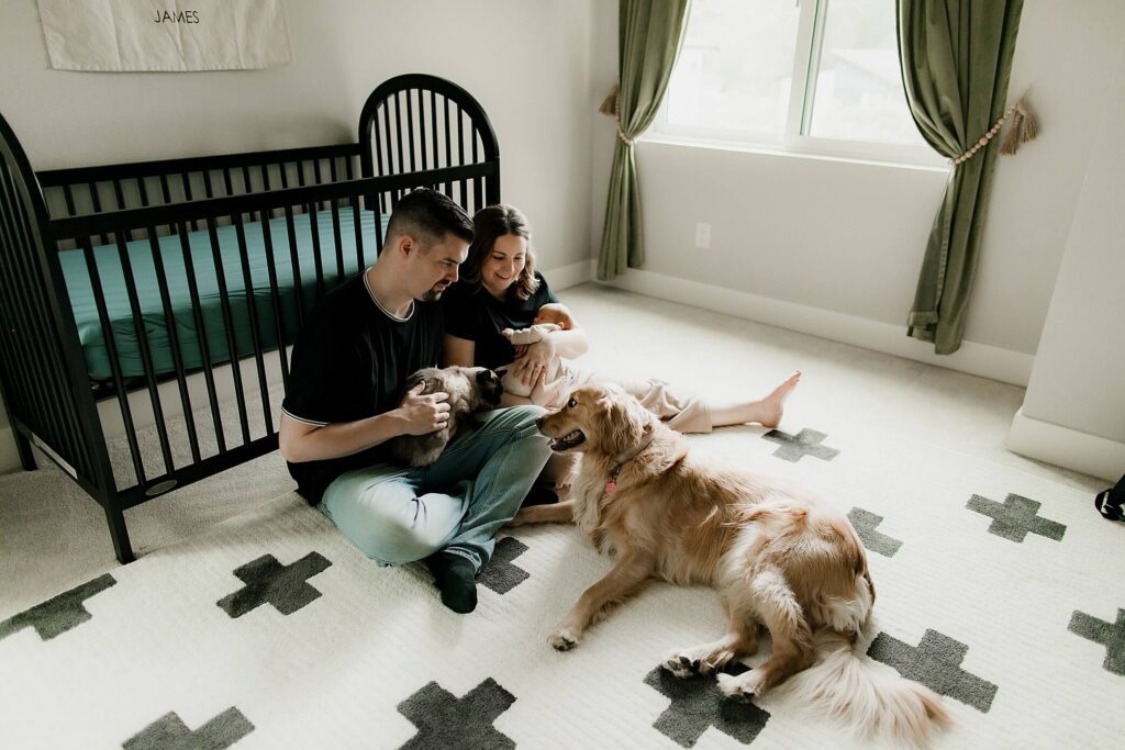 family sitting with baby boy and dog at newborn photo shoot in seattle